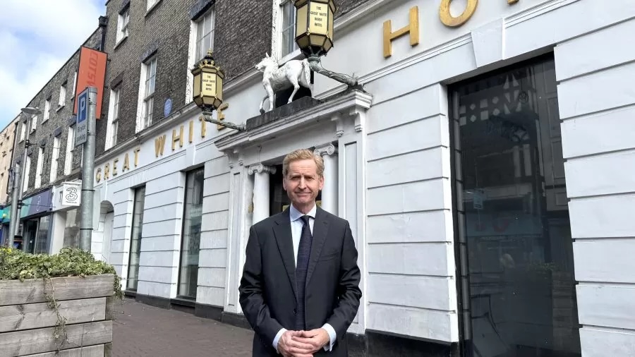 John outside a town-centre building